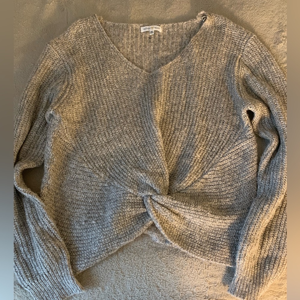 Grey sweater with a twist detail at the front.